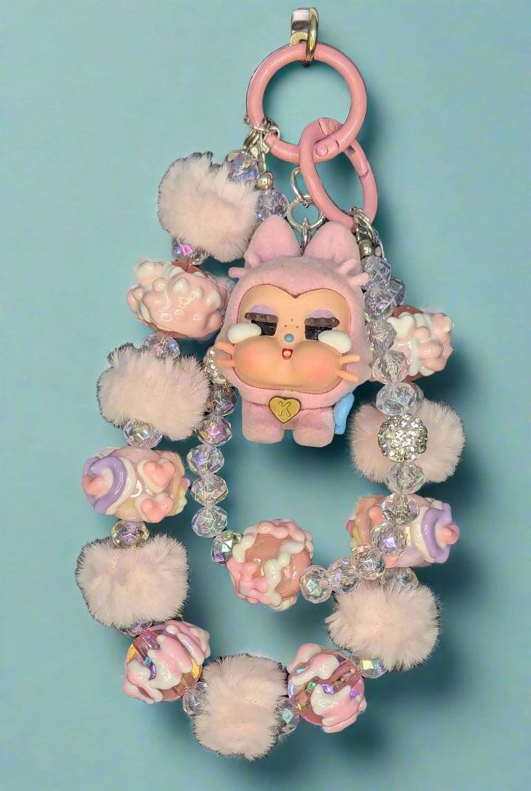 Keychain with plush elements and decorative beads on a dark background